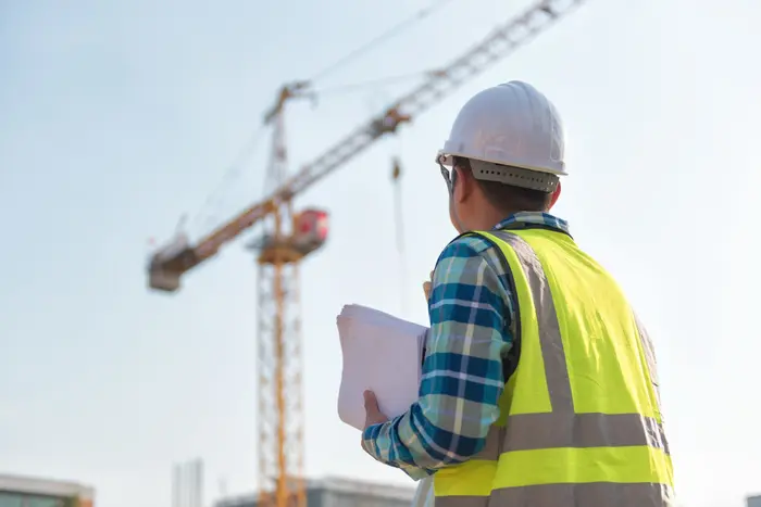 Project managers reviewing blueprints and coordinating construction activities on site.